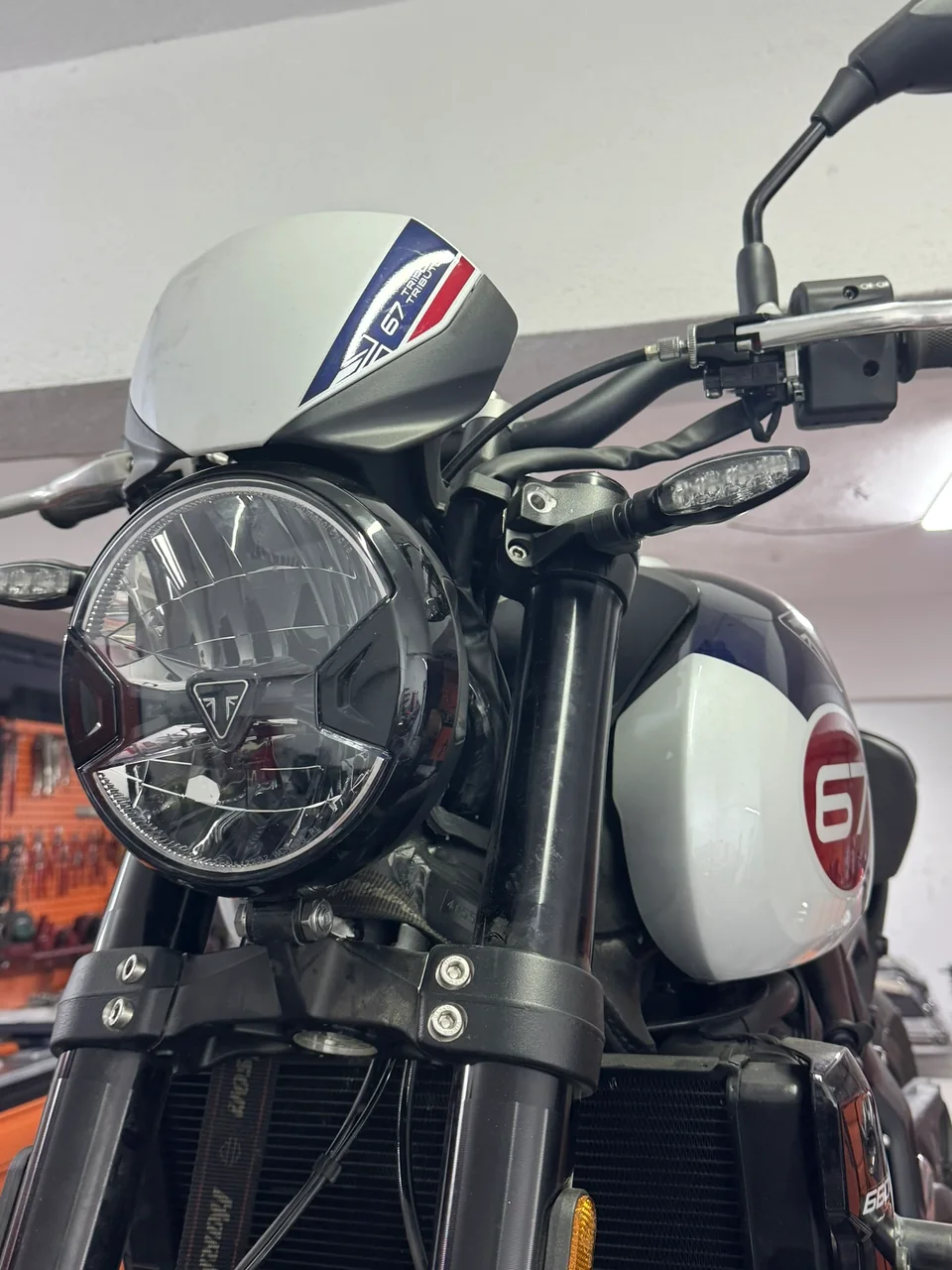 Close-up of a motorcycle headlight, handlebar and front controls