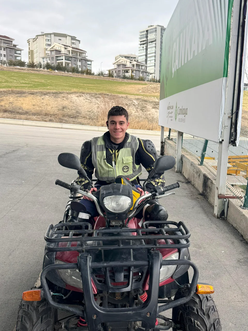 A person wearing a reflective vest on a parked ATV