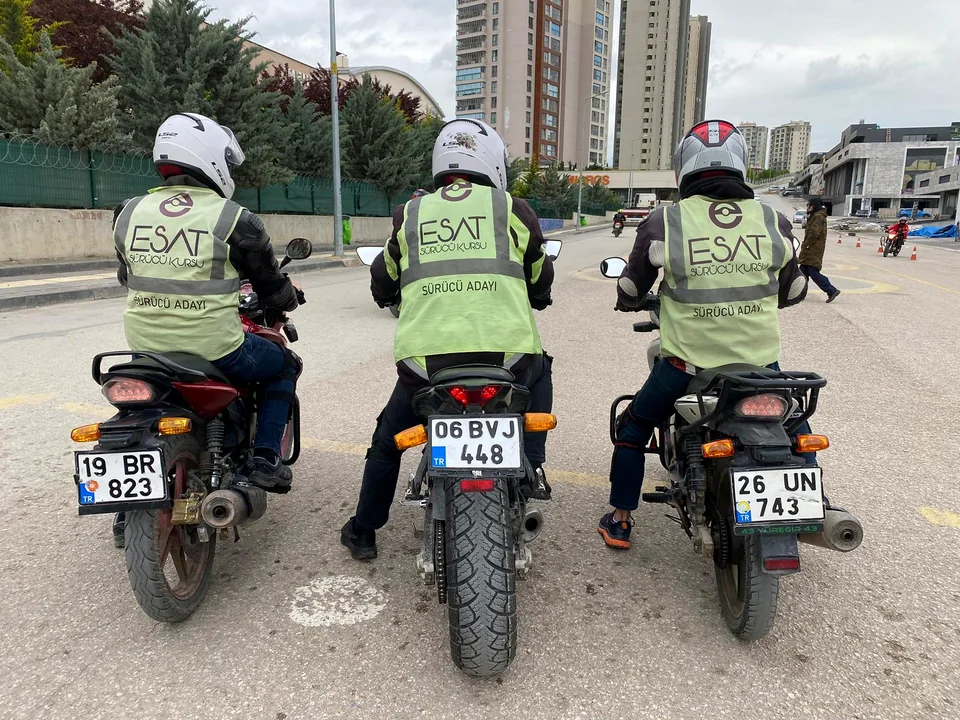 Rear view of three helmeted riders wearing Esat vests on their motorcycles