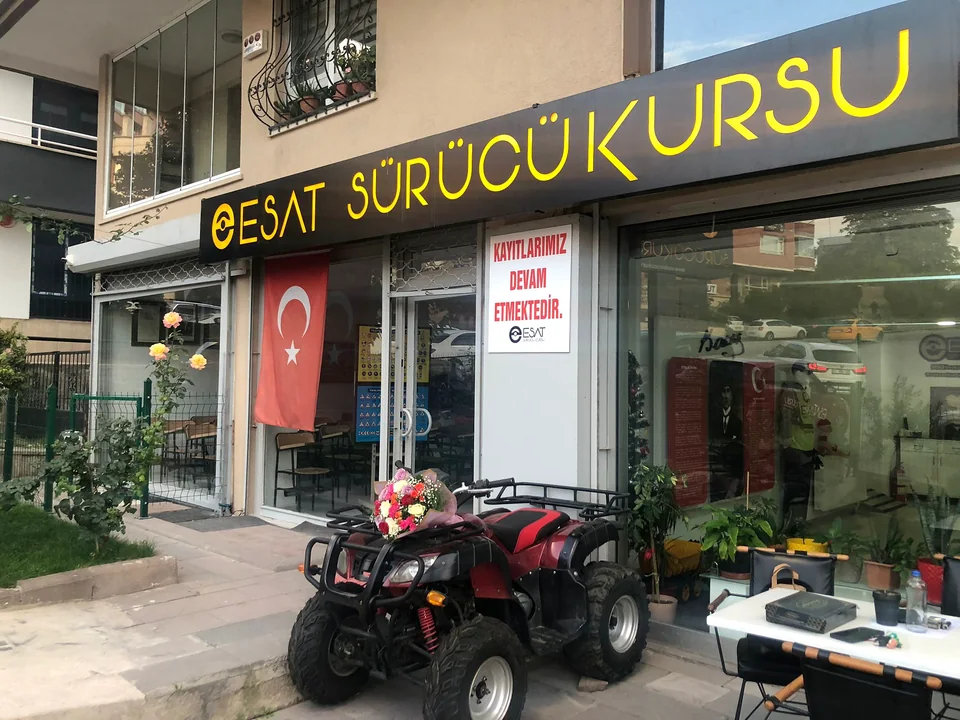Sign, Turkish flag and parked ATV at the entrance to Esat Driving School