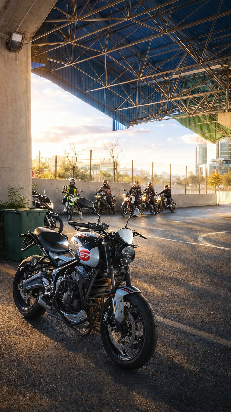 Üstü kapalı eğitim alanında motosiklet ve arkada kasklı sürücüler