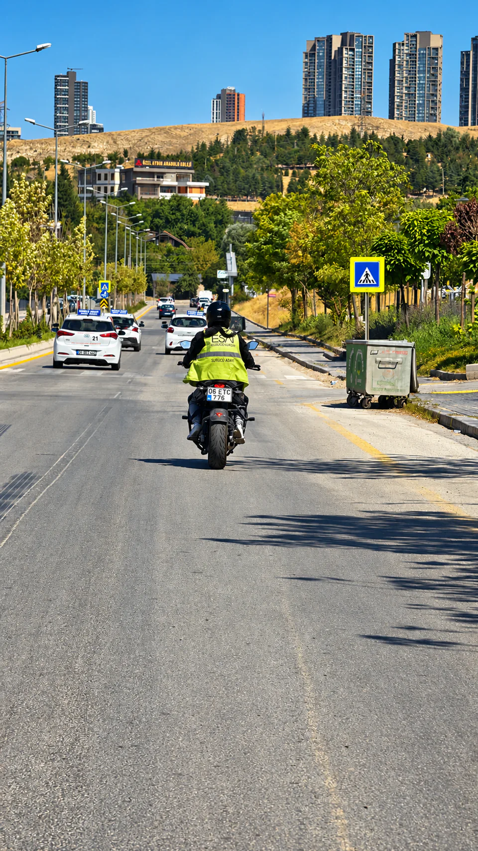 Şehir yolunda Esat yelekli ve kasklı motosiklet sürücüsü