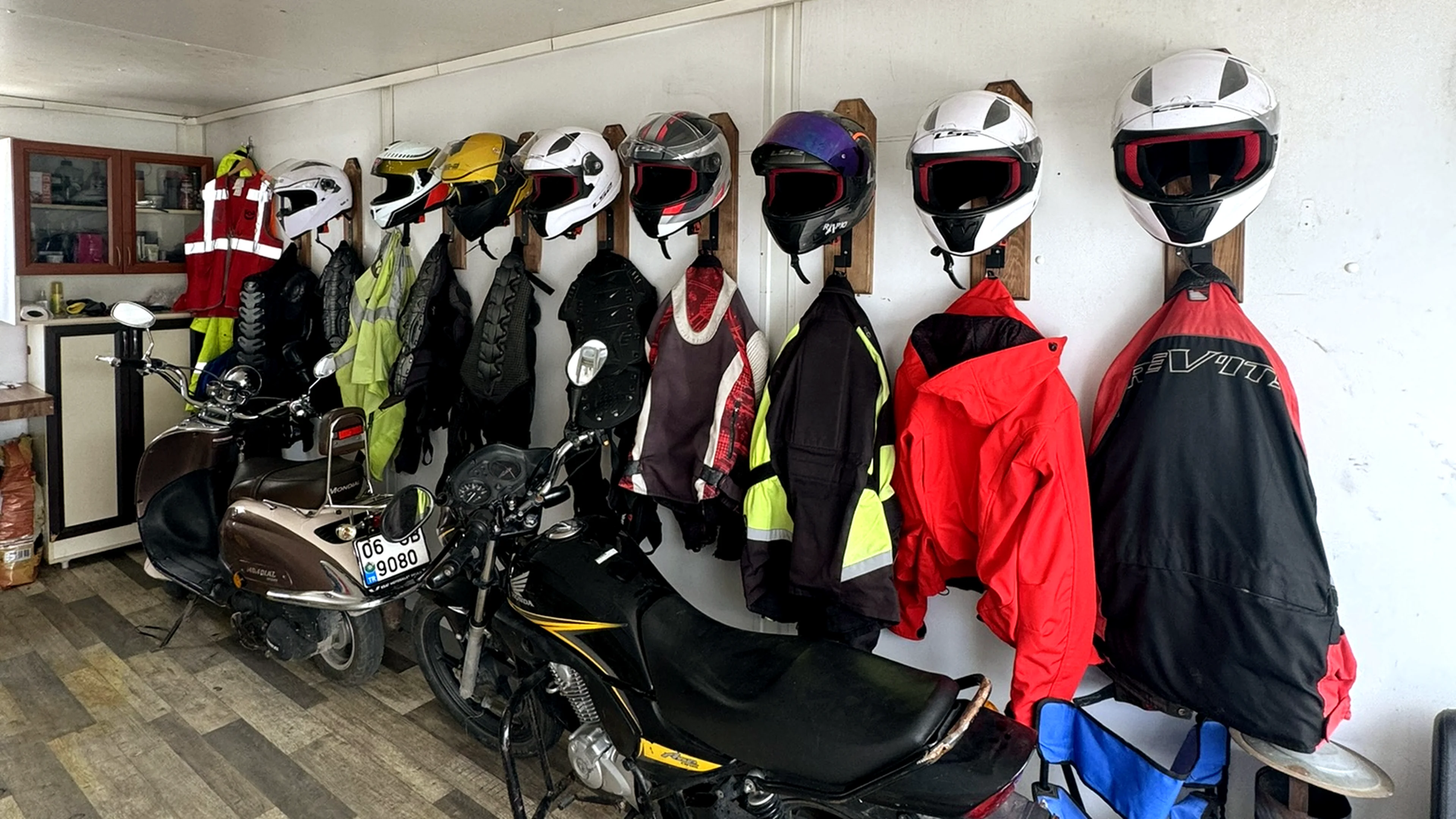 Kapalı alanda askıda kasklar ve motosiklet kıyafetleri